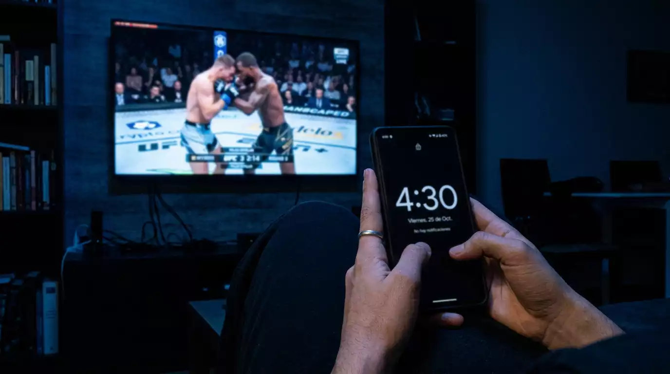 Reloj mostrando horario nocturno con octágono de UFC de fondo